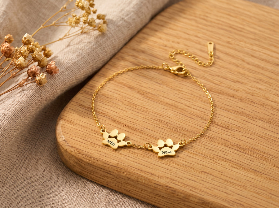 Bracelet patte finition or, 2 pattes gravées, sur une planche en chêne