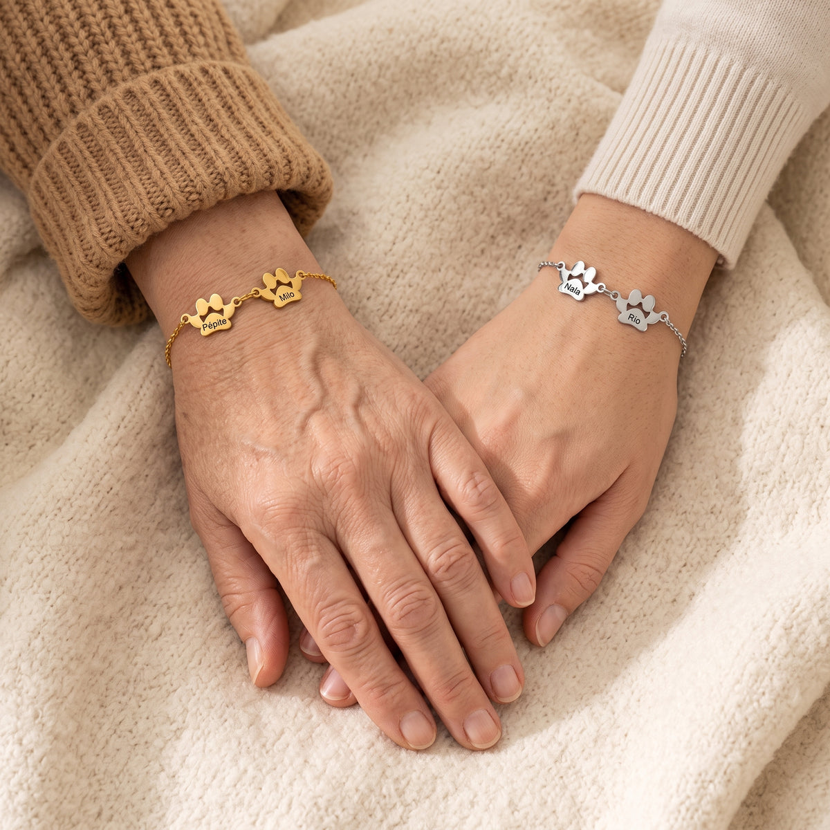 Une mère et sa fille se tiennent la main, l'une porte le bracelet or, l'autre le bracelet argent