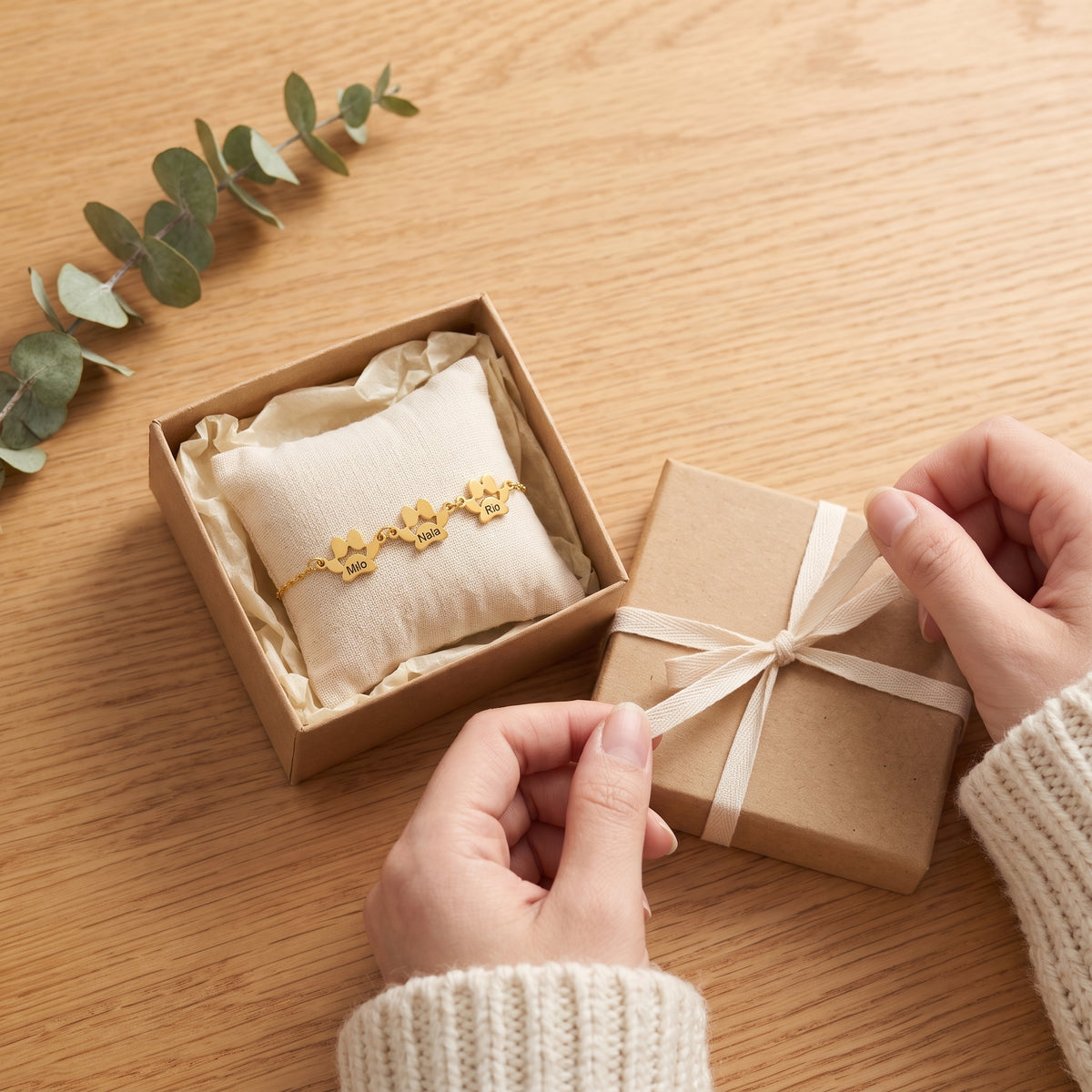 Bracelet patte en or à 3 pattes dans une boîte cadeau en kraft