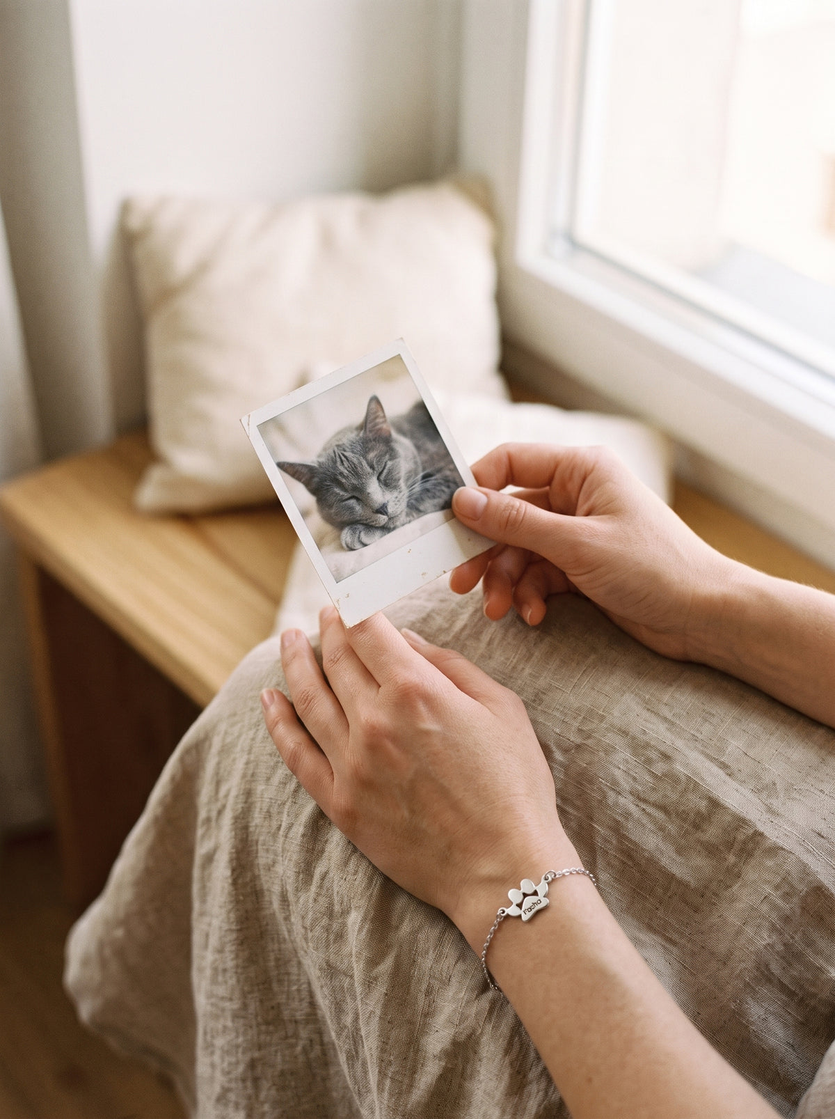 Femme qui tient la photo de son chat, bracelet patte en argent au poignet